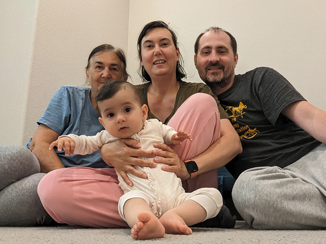 A family portrait including an older woman, a young woman and man, and a baby.