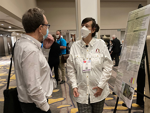 Two people in front of a poster at a scientific conference