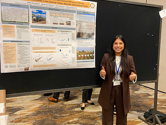 Woman in a brown suit in front of a research poster
