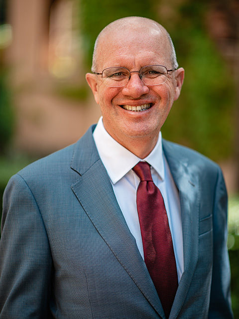 Man smiling, wearing a suit and tie