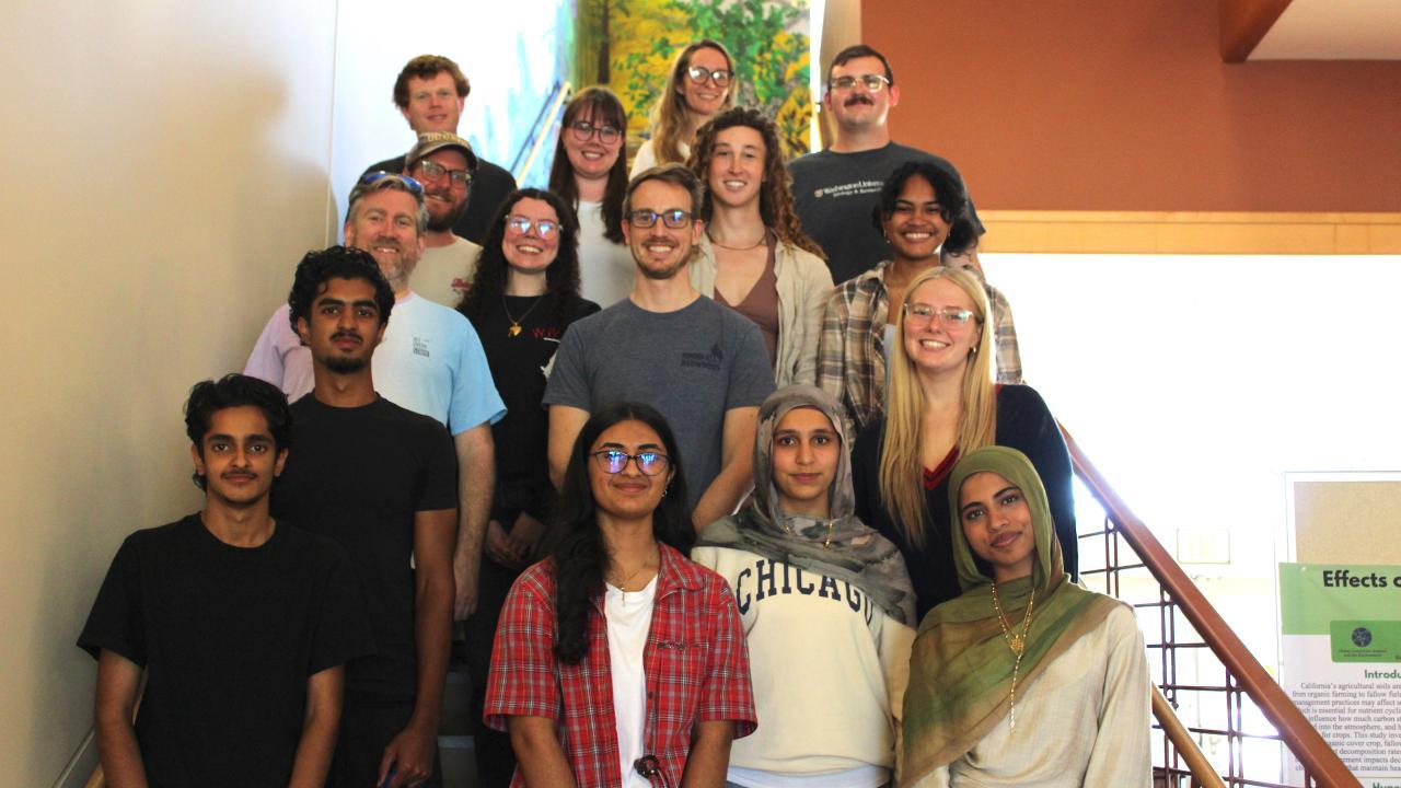 Group of diverse young people on indoor stairway, casually dressed, smiling.. UC Davis Department of Plant Sciences