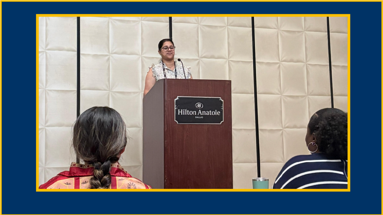 Young woman speaking at a podium in a beige-panel conference room, audience backs visible. UC Davis Department of Plant Sciences